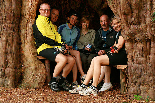 Cyclists sitting in the yew tree at Much Marcle church.